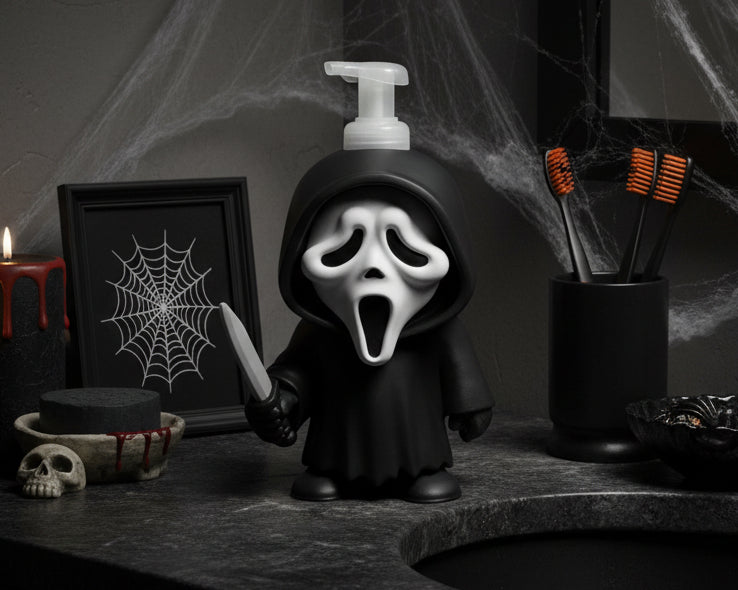 A Ghost soap dispenser featuring a black hooded figure with a white screaming mask and holding a knife, topped with a white pump bottle, set against a white studio backdrop.