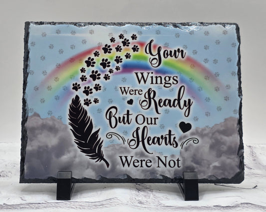 Memorial slate with rainbow, paw prints, and text on a gray background